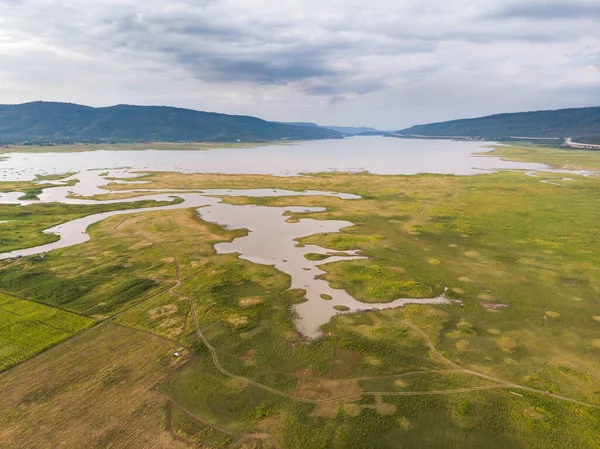 Nehir ve havzanın doğal bir dağa karşı manzaralı manzarası, Drone gürültülü ve tahıl işlenmiş tropikal araziyi vurdu.