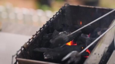 Yakın çekim, odun karbon kömürü ile barbekü ızgarasında yangın çıkardı. Dumanlı, seçici odaklı sığ alan derinliği...