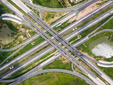 Drone, Tayland 'da yeşil tarlaların üzerinden geçen büyük bir otoyol kavşağını vurdu. Katmanlı yollar ve rampalar kırsal bir yerdeki modern ulaşım altyapısını vurguluyor