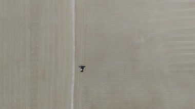 Drone videosu bir traktör cassava kurutma sahasına cassava yayıyor. Cassava un hazırlama süreci