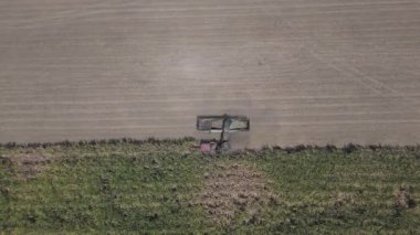 Traktörlerin ve kamyonların şeker kamışını şeker yapmak için çiftlikte topladıkları drone görüntüleri. Yanmadan çiftçilik yapmak