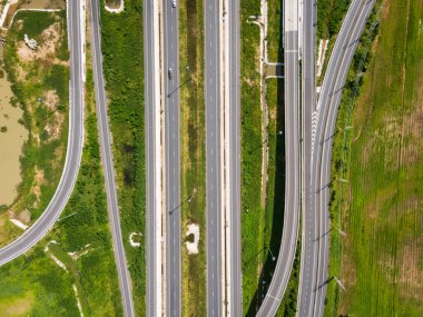 Drone, Tayland 'da yeşil tarlaların üzerinden geçen büyük bir otoyol kavşağını vurdu. Katmanlı yollar ve rampalar kırsal bir yerdeki modern ulaşım altyapısını vurguluyor