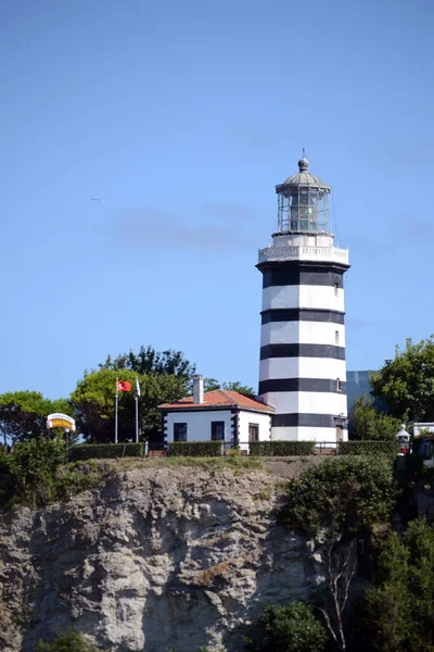 İstanbul deniz feneri ve kayalıklarda evler.