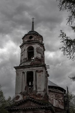 Gri gökyüzünün arka planında terk edilmiş eski bir kilise