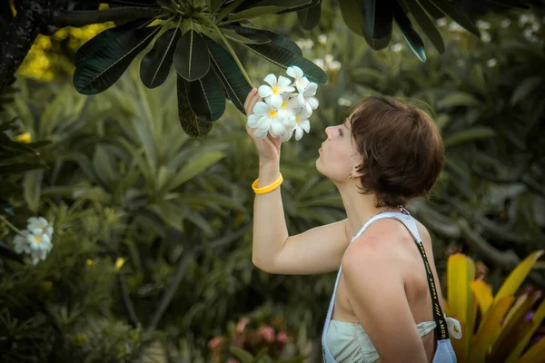 Una Chica Admira Una Hermosa Flor Tropical — Foto de Stock