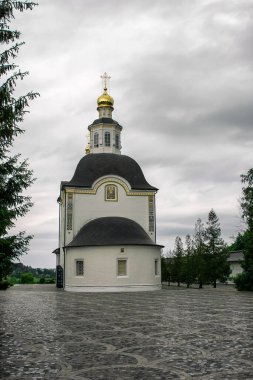 Bahçedeki yeşil ağaçlı küçük kilise.
