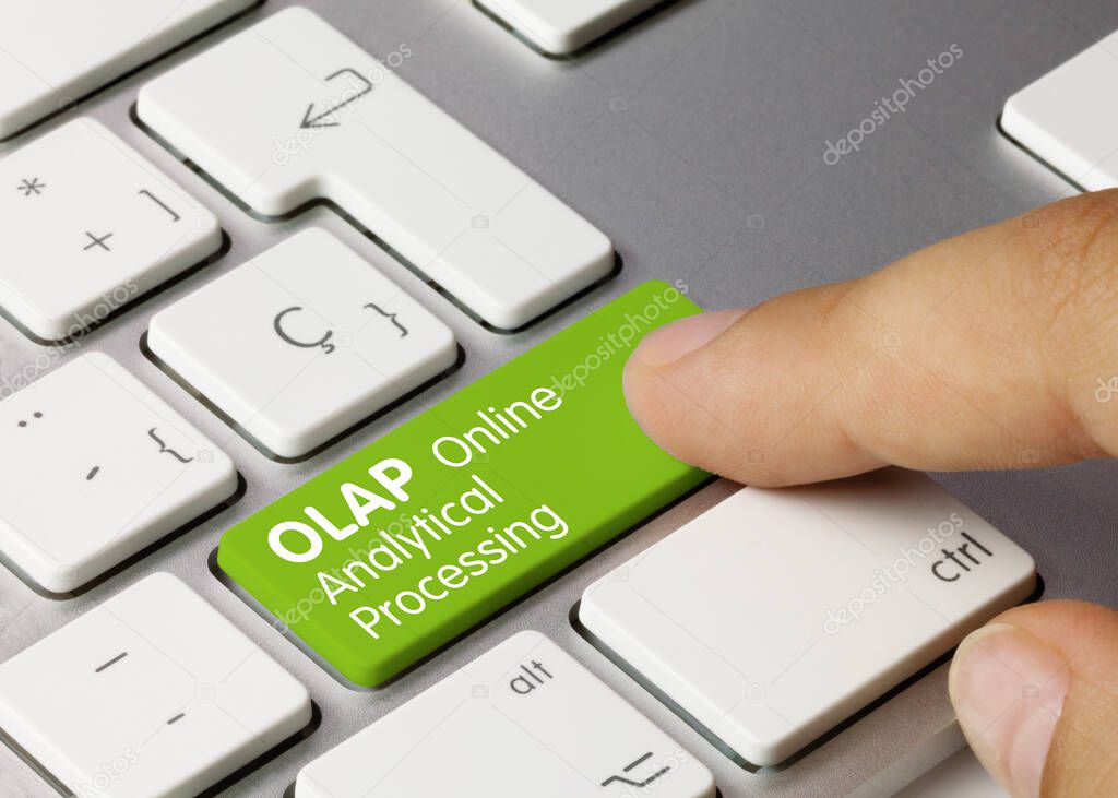 OLAP Online Analytical Processing Written on Green Key of Metallic Keyboard. Finger pressing key.