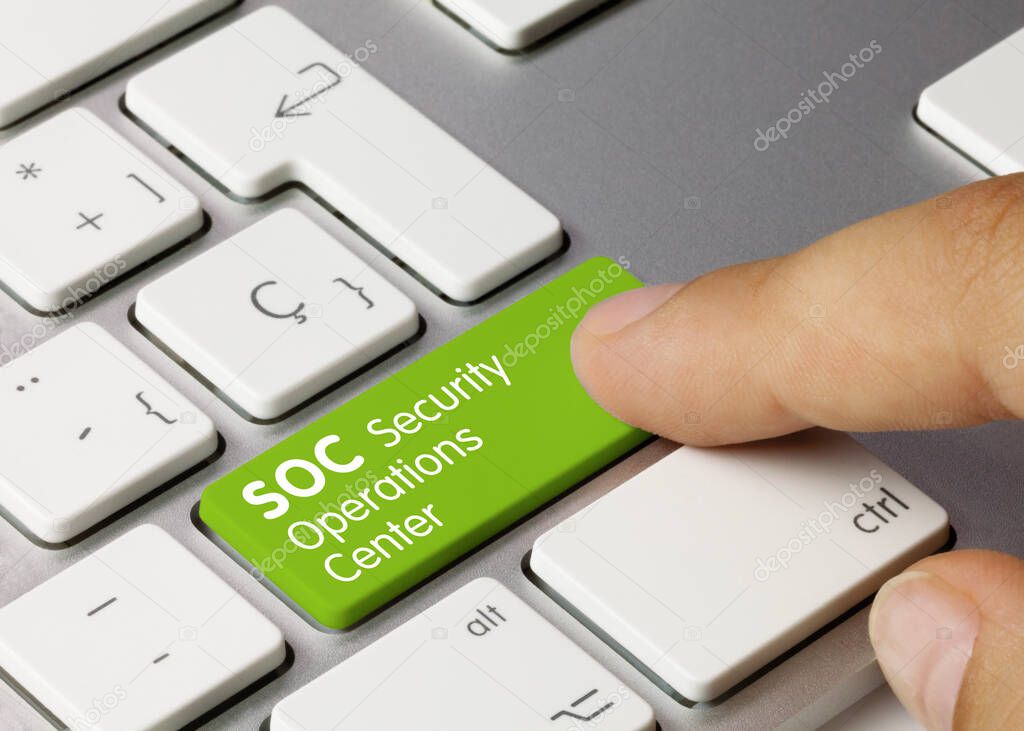 Security Operations Center Written on Green Key of Metallic Keyboard. Finger pressing key.