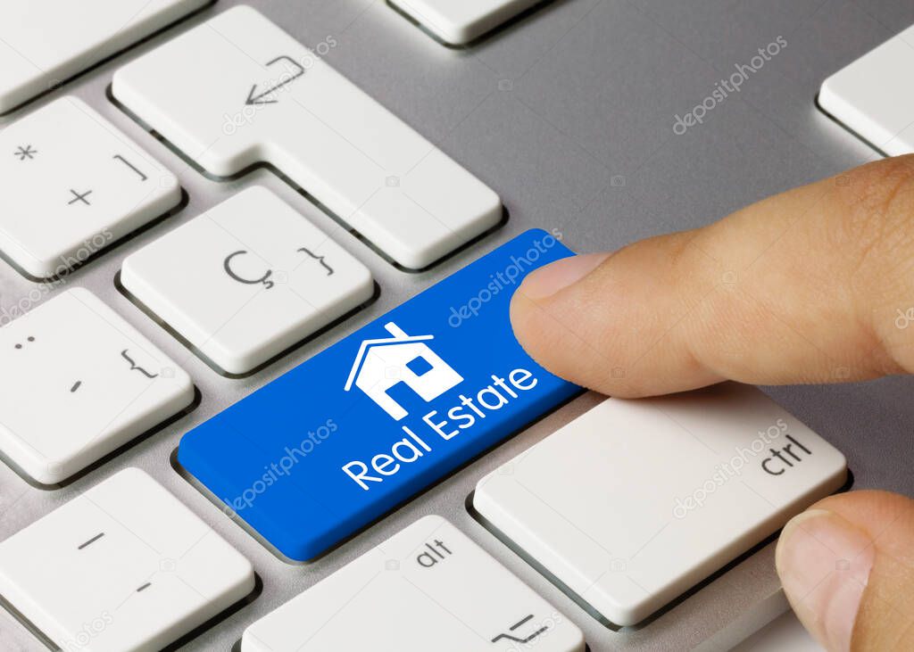 Real Estate Written on Blue Key of Metallic Keyboard. Finger pressing key