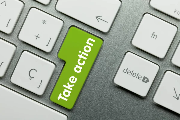 Take action Written on Green Key of Metallic Keyboard. Finger pressing key.