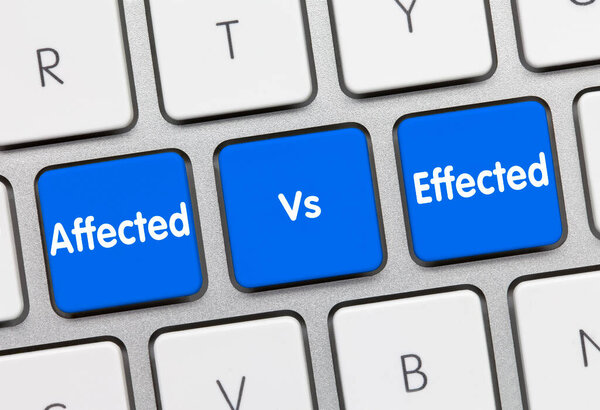 Affected Vs. Effected Written on Blue Key of Metallic Keyboard. Finger pressing key.