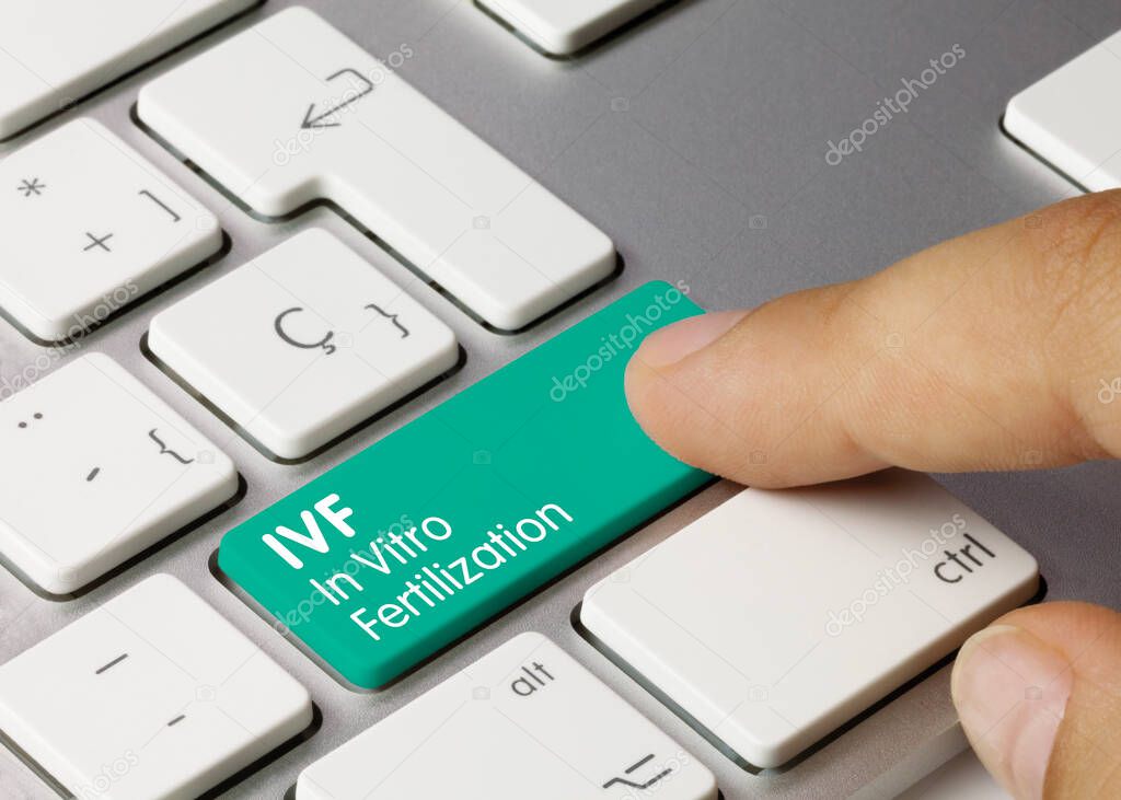 IVF In Vitro Fertilization Written on Green Key of Metallic Keyboard. Finger pressing key.