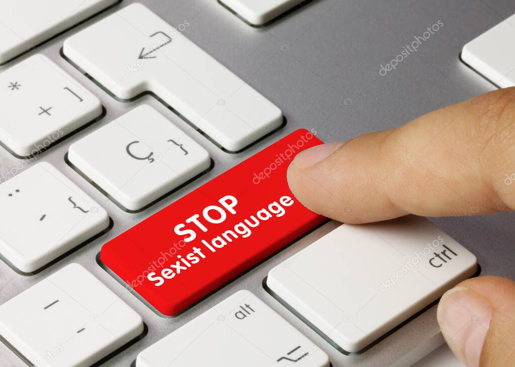 STOP Sexist language Written on Red Key of Metallic Keyboard. Finger pressing key.