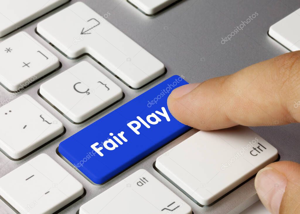 Fair Play Written on Blue Key of Metallic Keyboard. Finger pressing key.