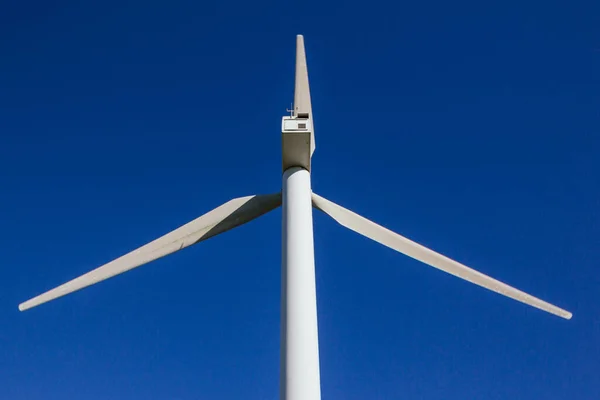 Stock photo of a big windmill taken from below with blue sky in the background