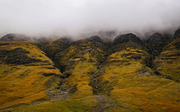 Soyut sonbahar İskoç manzarası. Glen Etive 'deki kayalıklar alçak bulutların arasında.