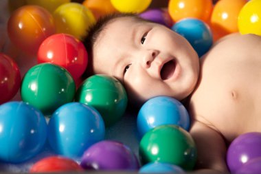 Renk toplarıyla çevrili bir bebek
