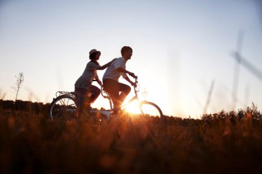 Bisiklet süren genç çift.