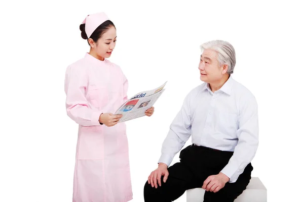 Sjuksköterskan Läser Tidningar För Patienten — Stockfoto