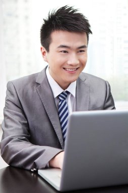 Ofiste dizüstü bilgisayar kullanan bir iş adamı