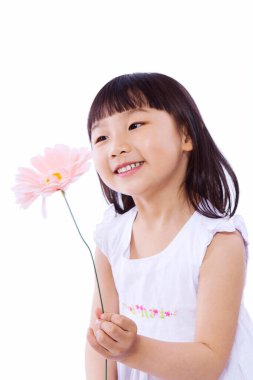 Elinde çiçekle duran küçük bir kız.