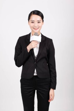 Bir iş kadını mikrofonu röportaj için tutuyor.