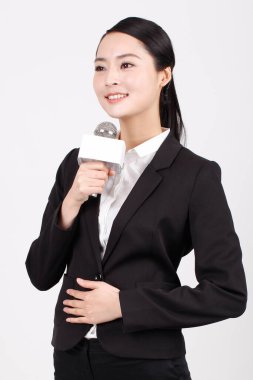 Bir iş kadını mikrofonu röportaj için tutuyor.