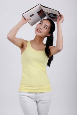 Elinde kitap tutan genç bir bayan.