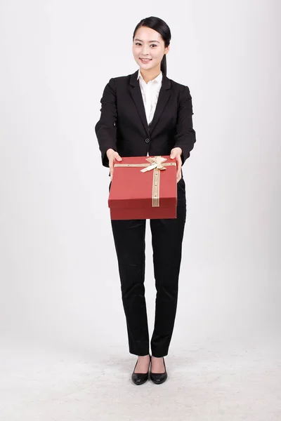 A business woman carrying a gift box