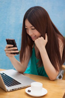 Kafedeki bilgisayarın başında çalışan kadın.