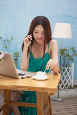 Kafedeki bilgisayarın başında çalışan kadın.