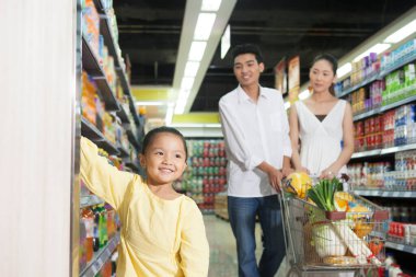 Süpermarkette üç kişilik mutlu bir aile.