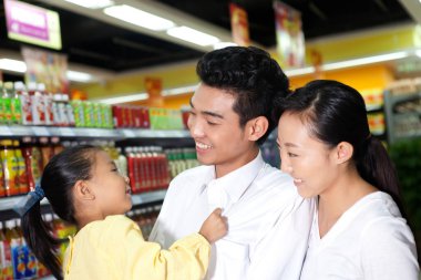 Süpermarkette üç kişilik mutlu bir aile.