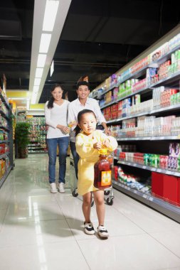 Süpermarkette üç kişilik mutlu bir aile.