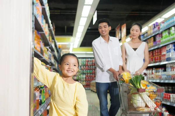 Süpermarkette üç kişilik mutlu bir aile.