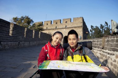 Genç bir kadın Çin Seddi turizminde telsiz kullanıyor.