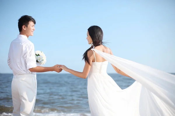 在海滩上穿婚纱的情侣 — 图库照片