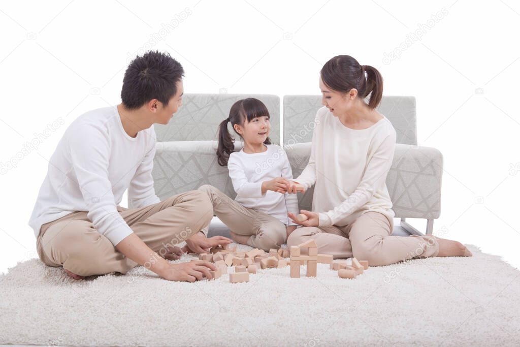 	Portrait of daughter playing building blocks with parents	