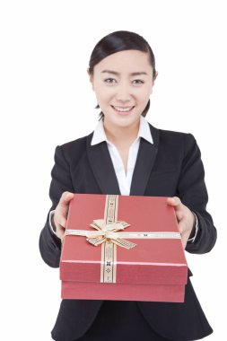 İş kadını elinde hediye kutusu tutuyor.