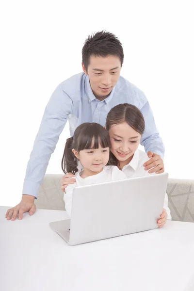 Portrait of daughter playing laptop  with parents