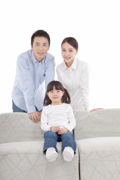女儿坐在沙发上 父母站在后面的画像 — 图库照片