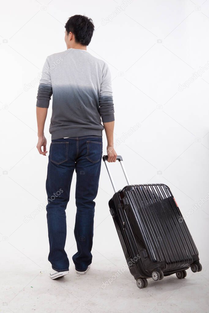 	Portrait of young bisinessman pulling valise	