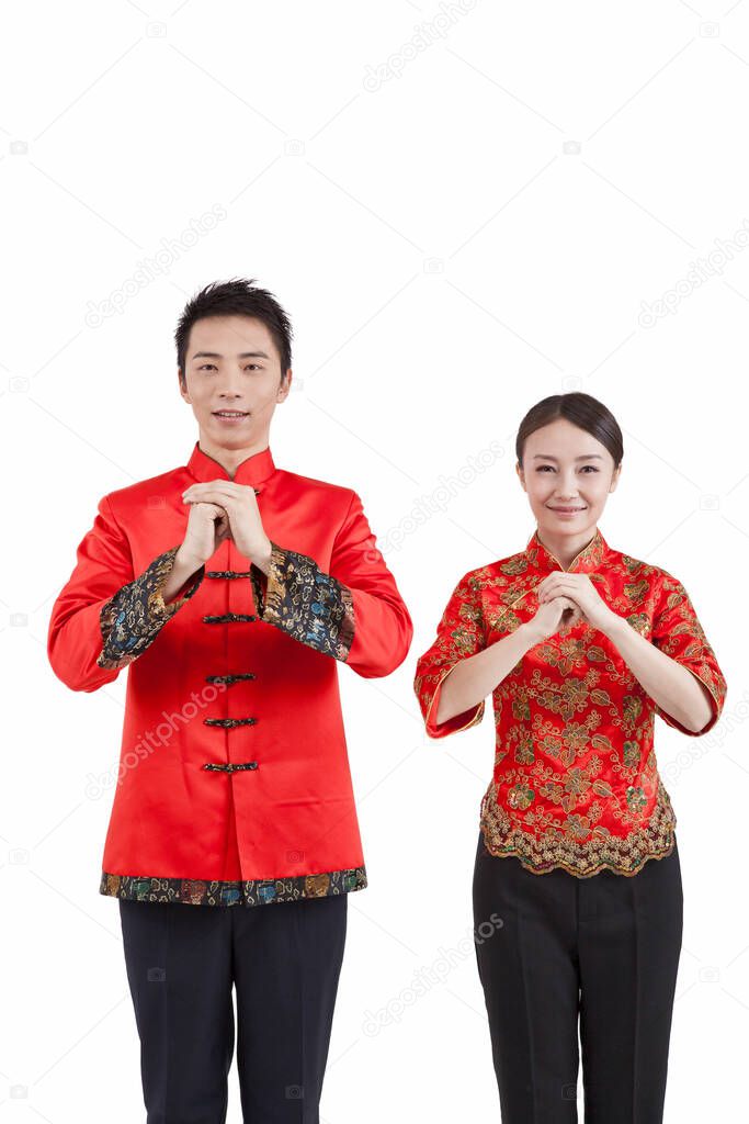 	Portrait of young couple in Tang suits paying New Year call 	