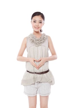 Genç bir kadının elleri kalp oluşturuyor.