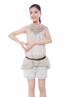 Genç bir kadının elleri kalp oluşturuyor.