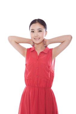 Elleri boynunda, gülümseyen genç bir kadın.