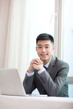 Laptopun önünde oturan genç bisikletçinin portresi.