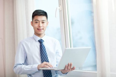 Laptop kullanan genç bisikletçinin portresi