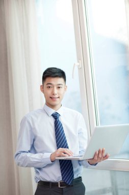 Laptop kullanan genç bisikletçinin portresi