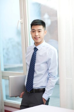 Laptop kullanan genç bisikletçinin portresi